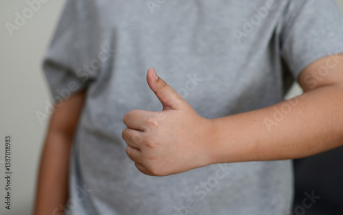 Obraz na płótnie Child's hand thumb up is a symbol w salonie