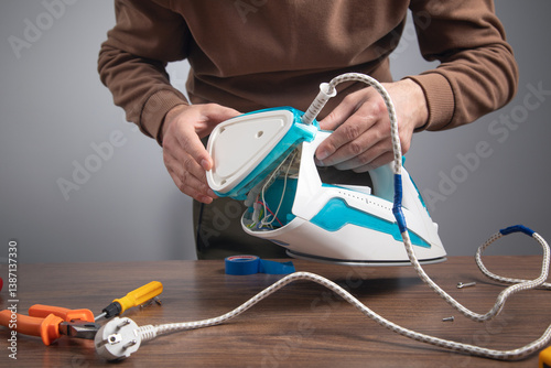 Caucasian man repairing broken iron. Iron repair
