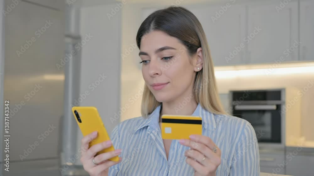 Young woman smiling while using credit card for mobile payment in modern kitchen. High quality 4k footage Young woman smiling while using credit card for mobile payment in modern kitchen. High quality 4k footage