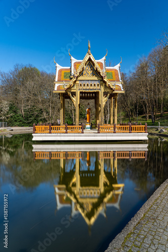 Thailändischer Tempel im Münchner Westpark spiegelt sich im Wasser