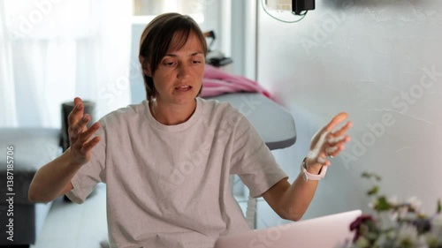 Young woman sitting in front of a laptop screen, looking angry and upset, expressing frustration. Perfect for themes of remote work, freelancing, or work from home challenges.