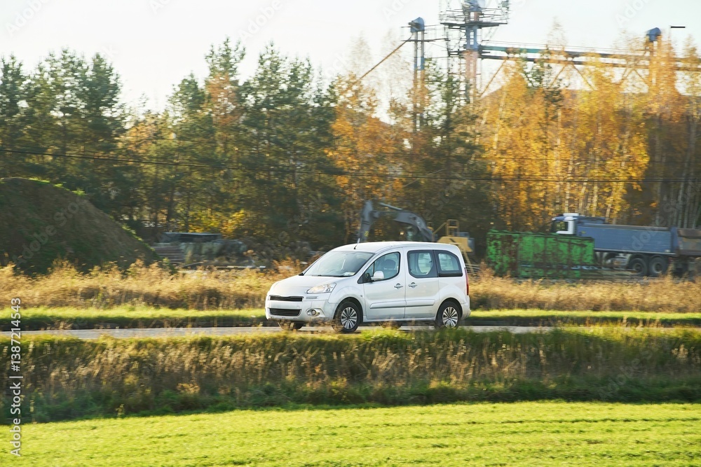 White delivery van passing grassy field