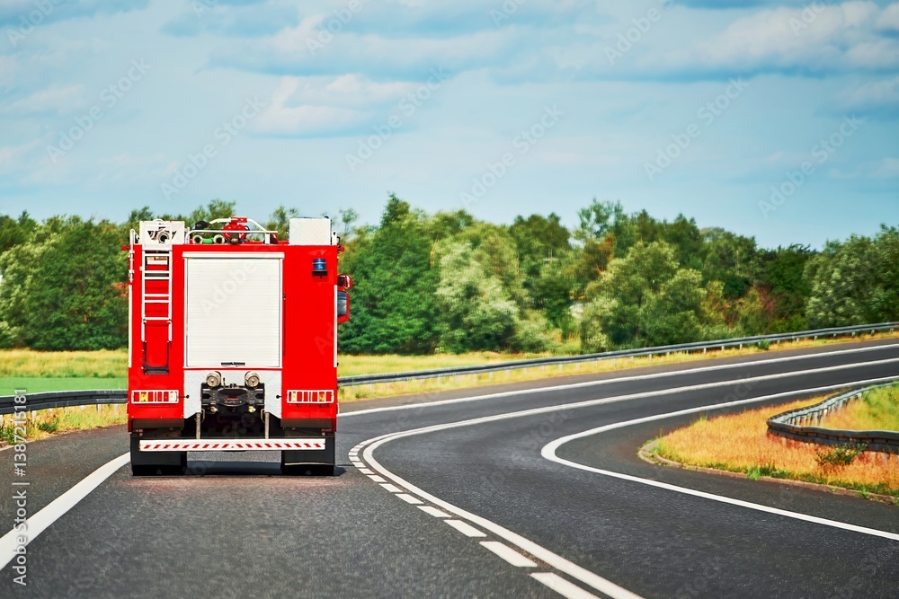 Fire truck on duty driving through countryside area