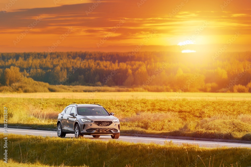 Sunset drive in a stylish SUV through rural landscape