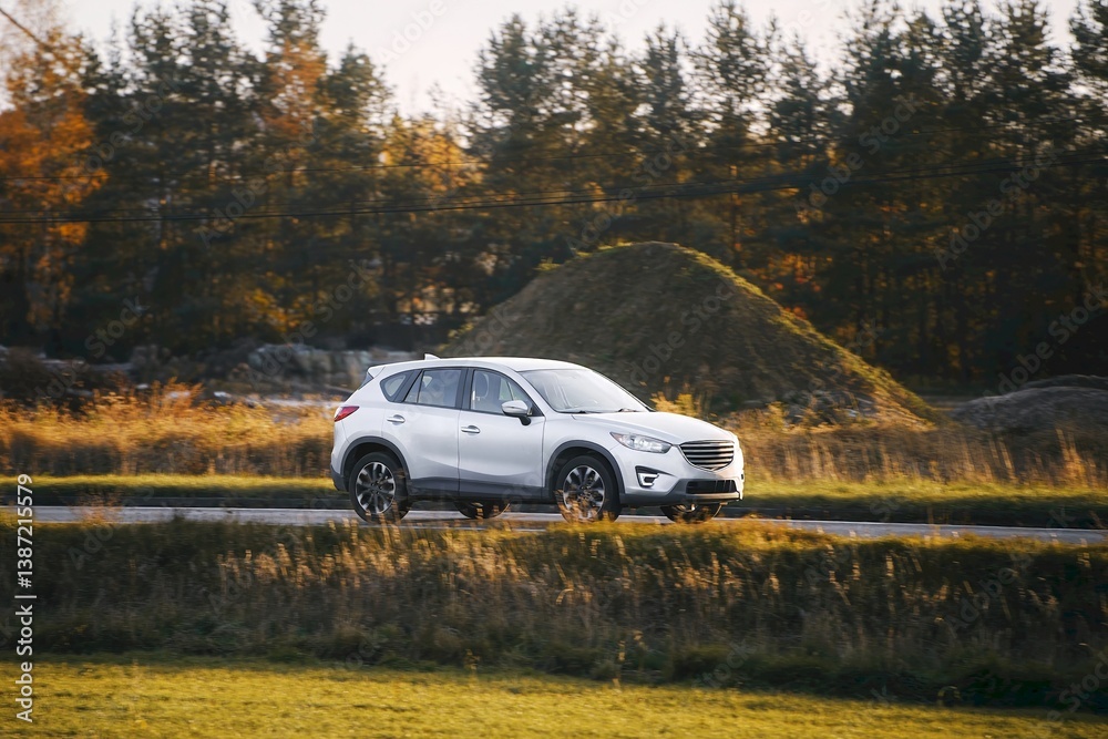 Modern hybrid car on scenic countryside road