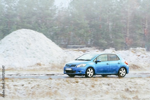 Shiny compact car on frosty mountain roadway
