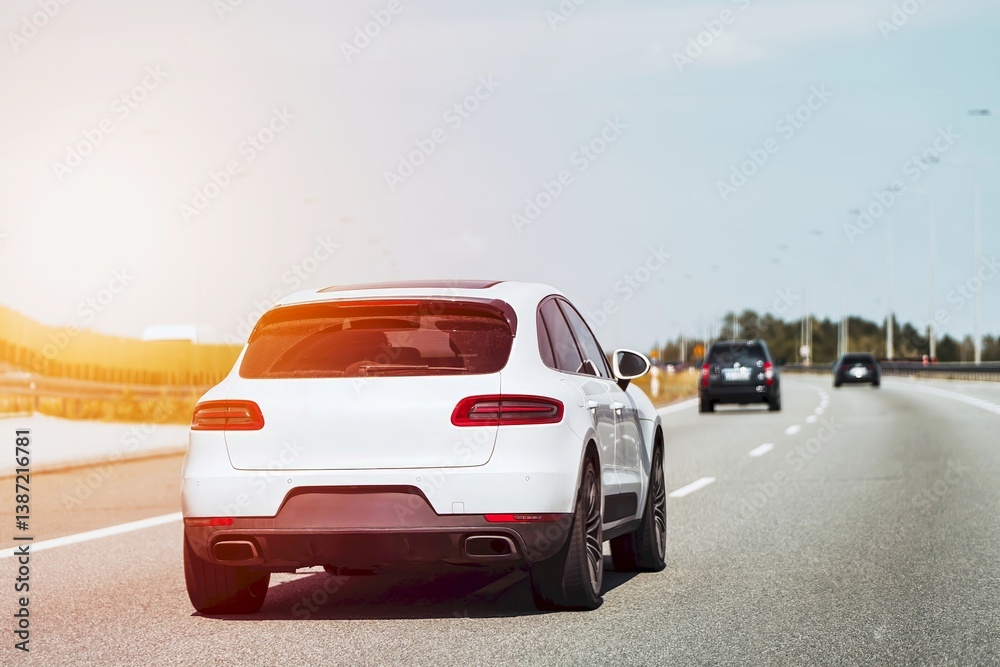 White car cruising down an empty highway.