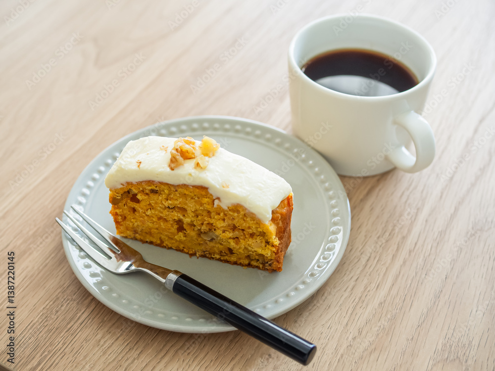 皿の上のキャロットケーキとホットコーヒー 皿の上のキャロットケーキとホットコーヒー