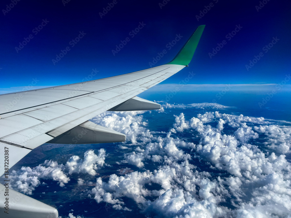 view from airplane window with blue sky and white clouds view from airplane window with blue sky and white clouds