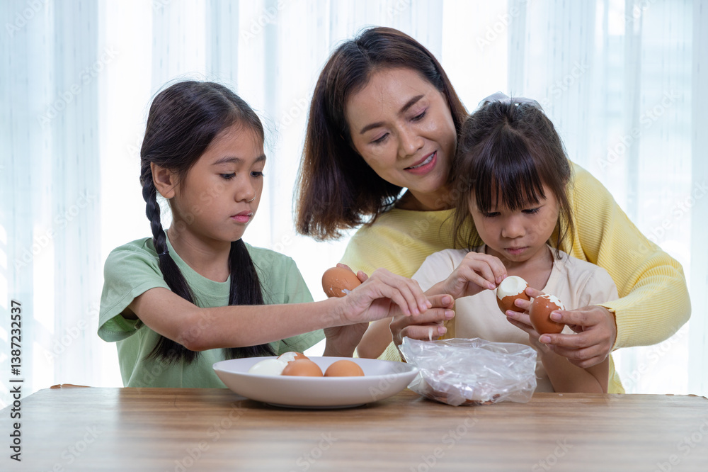 Happy family, father, mother and daughter are having fun peeling eggs in the living room Happy family, father, mother and daughter are having fun peeling eggs in the living room