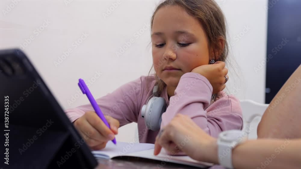 Mother and daughter sitting together, using a tablet for homework. A scene of home schooling and online education. Perfect for themes of learning, parenting, or technology in education. Mother and daughter sitting together, using a tablet for homework. A scene of home schooling and online education. Perfect for themes of learning, parenting, or technology in education.
