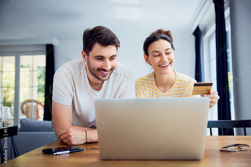 Young couple paying with credit card for online shoping using laptop at home Young couple paying with credit card for online shoping using laptop at home
