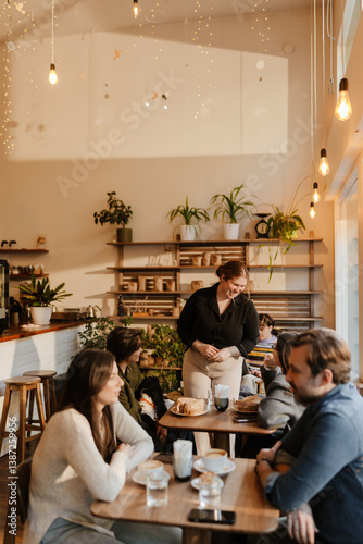 Photography A young, overweight White woman in her late 20s, talking to a few customers in h