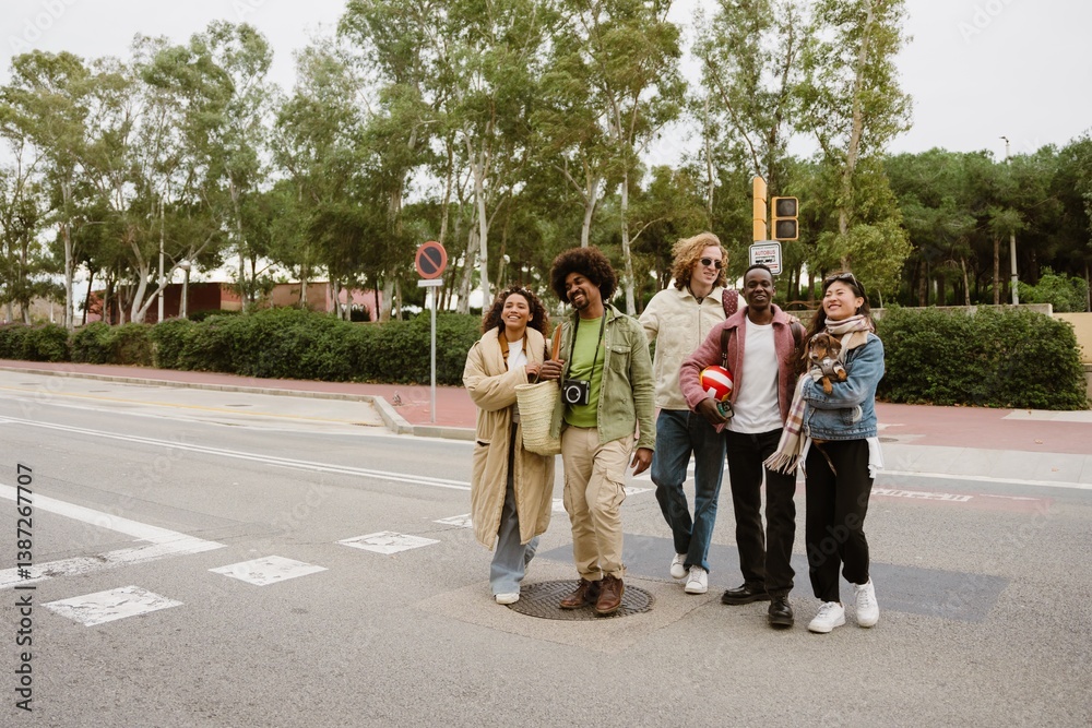 Obraz premium A young Black man in his late 20s, smiling as he walks across the road with his young Latina girlfriend by his side and their three adult friends next to them, on a city street