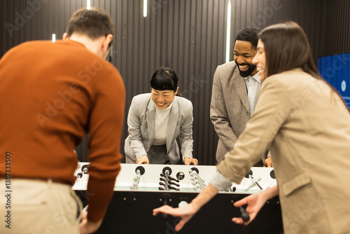 Joyful celebration among friends during a foosball game in a stylish indoor setting