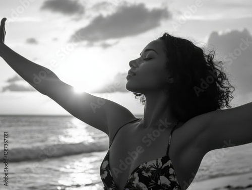 Woman in bikini with arms outstretched, enjoying the warmth of a tropical sunset