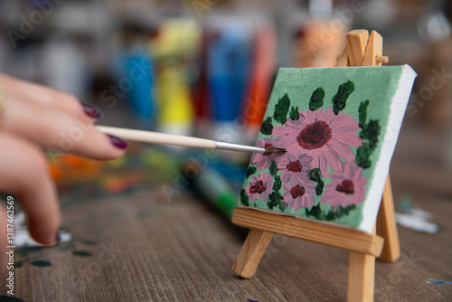 Obraz na płótnie A vibrant floral painting beautifully displayed on a charming mini easel for art lovers w salonie