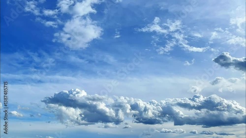 Timelapse of dramatic cloud formations drifting across a bright blue sky, capturing the serene motion of nature’s ever-changing atmosphere.