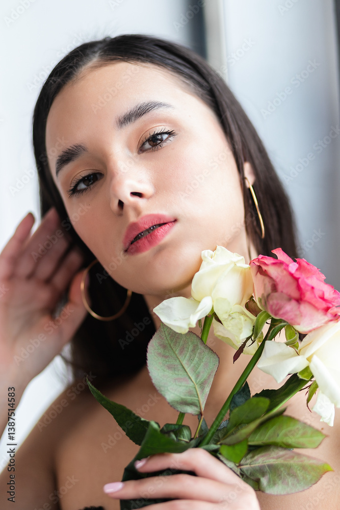 young beautiful woman smelling a bunch of red roses young beautiful woman smelling a bunch of red roses