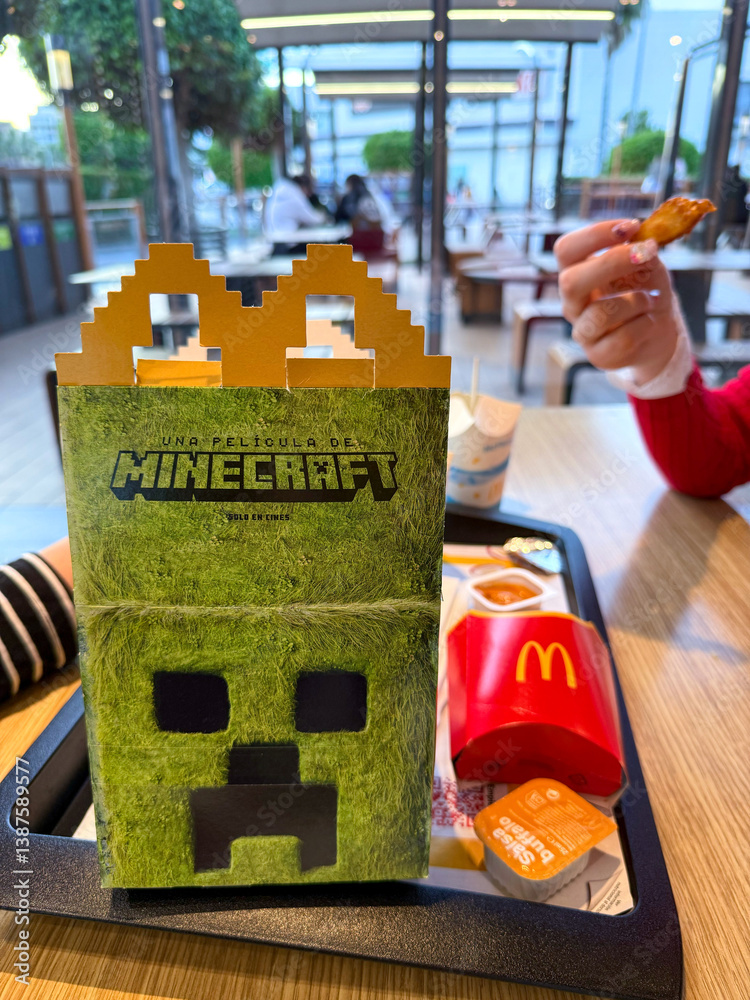 Naklejka premium McDonald's themed food box in Minecraft style with iconic character, colorful french fries and nuggets on wooden table, fast food concept