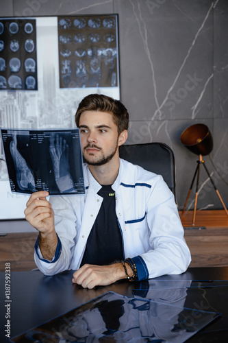 Young doctor radiologist, holds pictures in his hands. rengenanoliya photo
