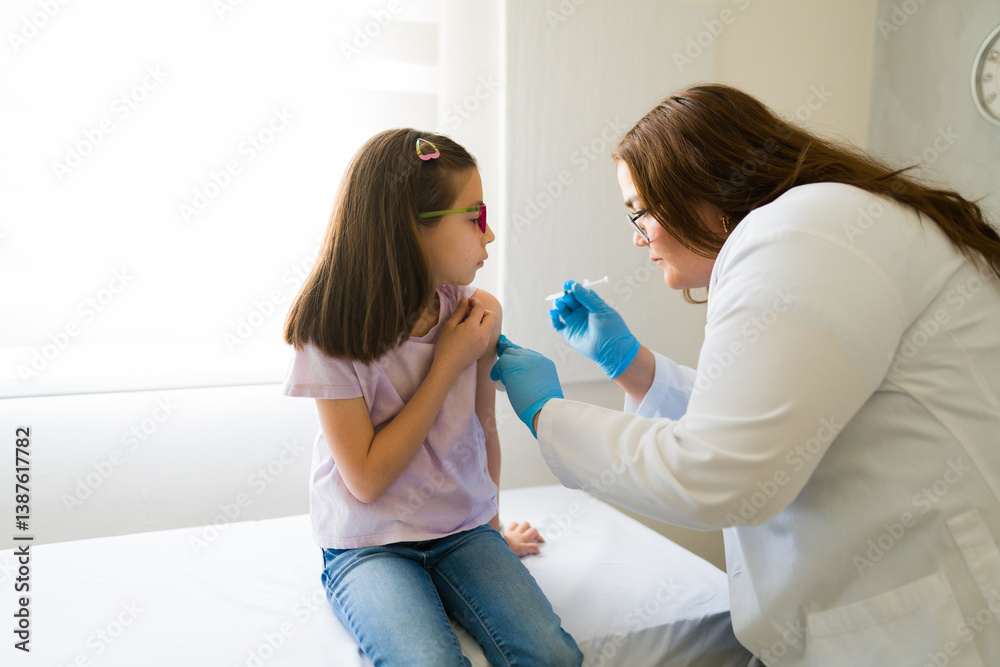 Female pediatrician vaccinating a little girl in a doctor's office, providing essential healthcare and disease prevention