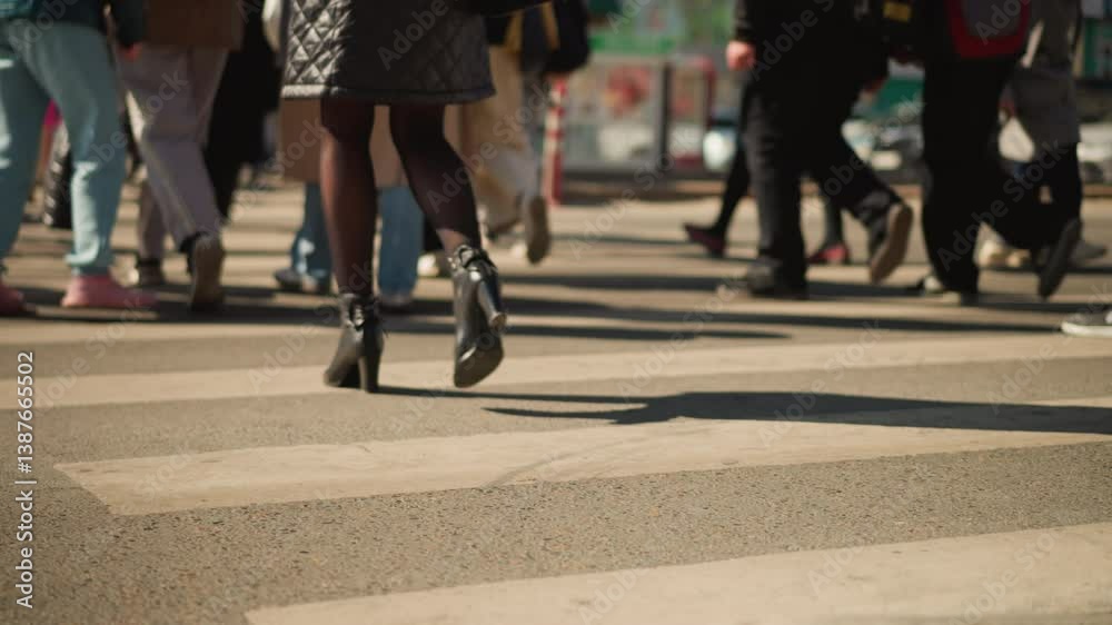Close-up of pedestrians walking on crosswalk, showing women in black heels and men in casual footwear, with focus on movement in urban setting, highlighting busy street life and street fashion Close-up of pedestrians walking on crosswalk, showing women in black heels and men in casual footwear, with focus on movement in urban setting, highlighting busy street life and street fashion