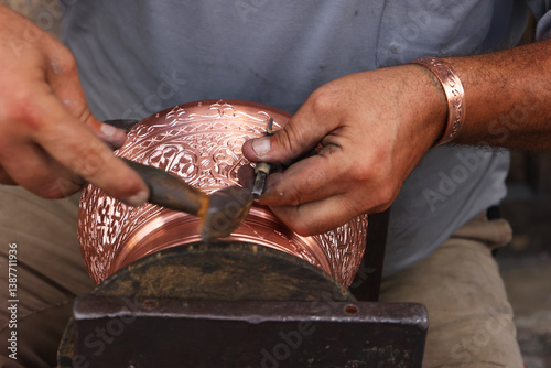 Traditional coppersmithing in Gaziantep. Craftsman engraving on a copper metal plate