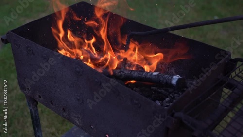 Fixing coals in the grill with a poker. Coals in the grill