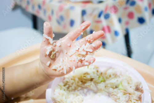Asian baby using hand eating food. hand in food.