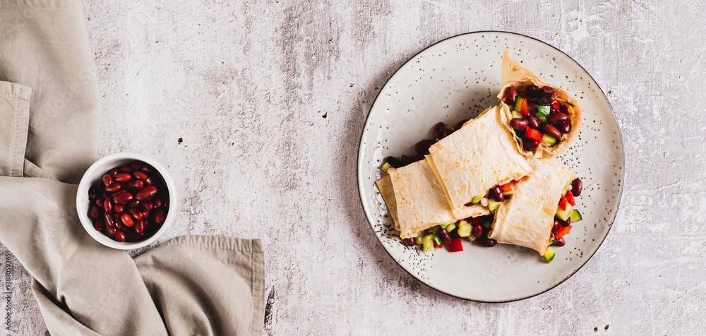 Vegetarian salsa rolls in tortilla on plate on table top view web banner