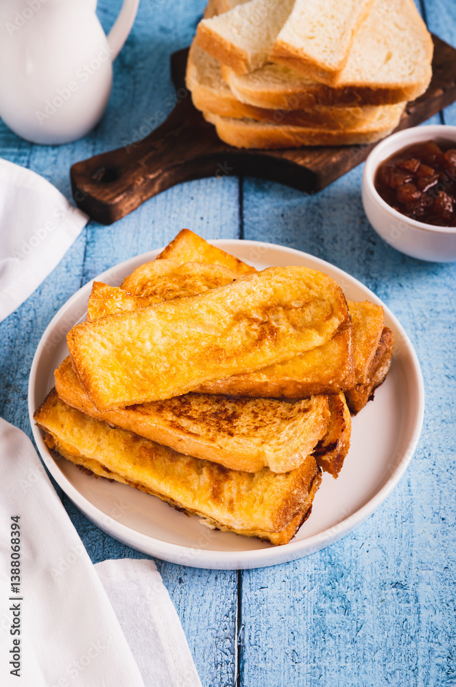 Traditional fried french toasts on white plate on table vertical view