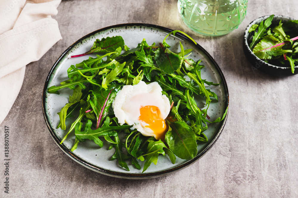 Leafy greens and poached egg on a plate on a table