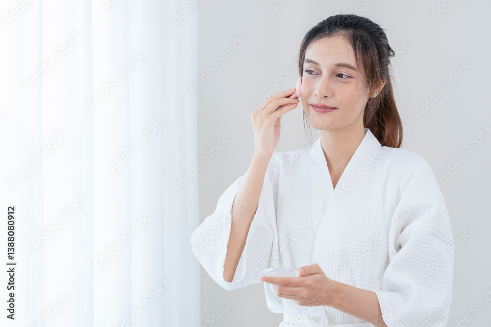 woman beauty concept,young pretty woman in bathrobe using cosmetic brush applying on cheek,with copy space for text woman beauty concept,young pretty woman in bathrobe using cosmetic brush applying on cheek,with copy space for text