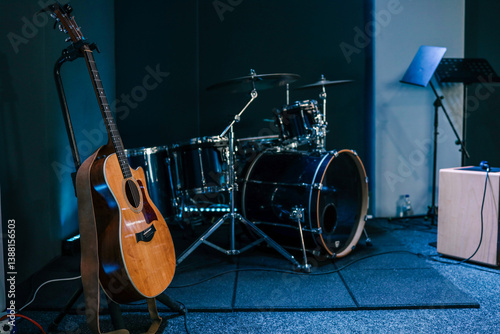 Obraz na płótnie Acoustic guitar on stand next to a drum kit on a stage in a music rehearsal or worship room w salonie
