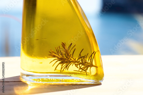 Olive oil with rosemary inside in front of the Mediterranean
