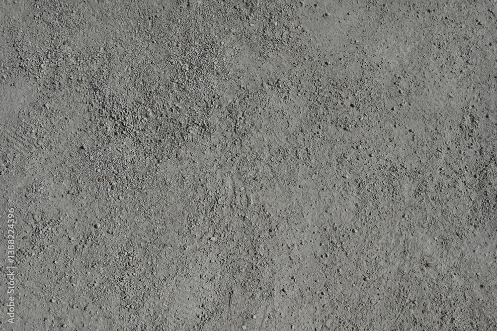Fototapeta premium texture of dry grey soil with fine grains and natural irregularities. A neutral earthy background suitable for environmental themes, agriculture, nature studies, and texture overlays.