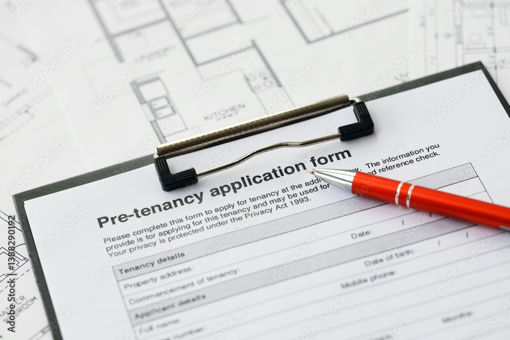 Pen on pre-tenancy application form and planning blueprints of residential building project close up. Pre tenancy application signature concept Pen on pre-tenancy application form and planning blueprints of residential building project close up. Pre tenancy application signature concept