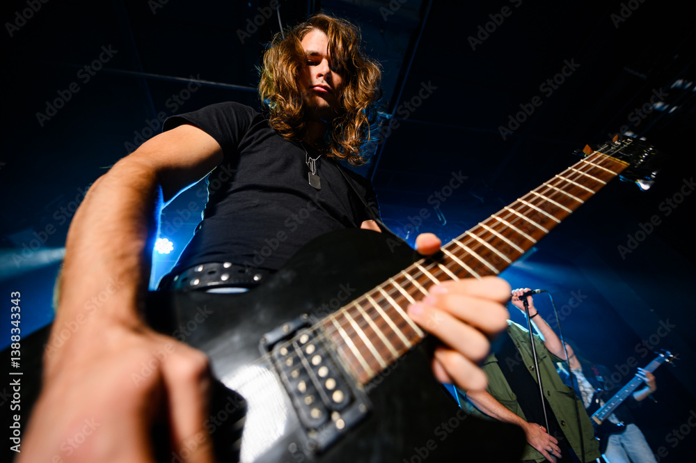 Fototapeta premium Guitarist performing live music on stage with band