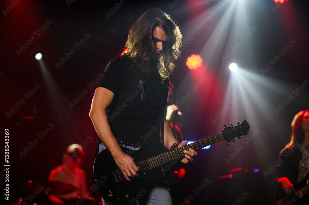 Obraz premium Guitarist performing live on stage with bandmates