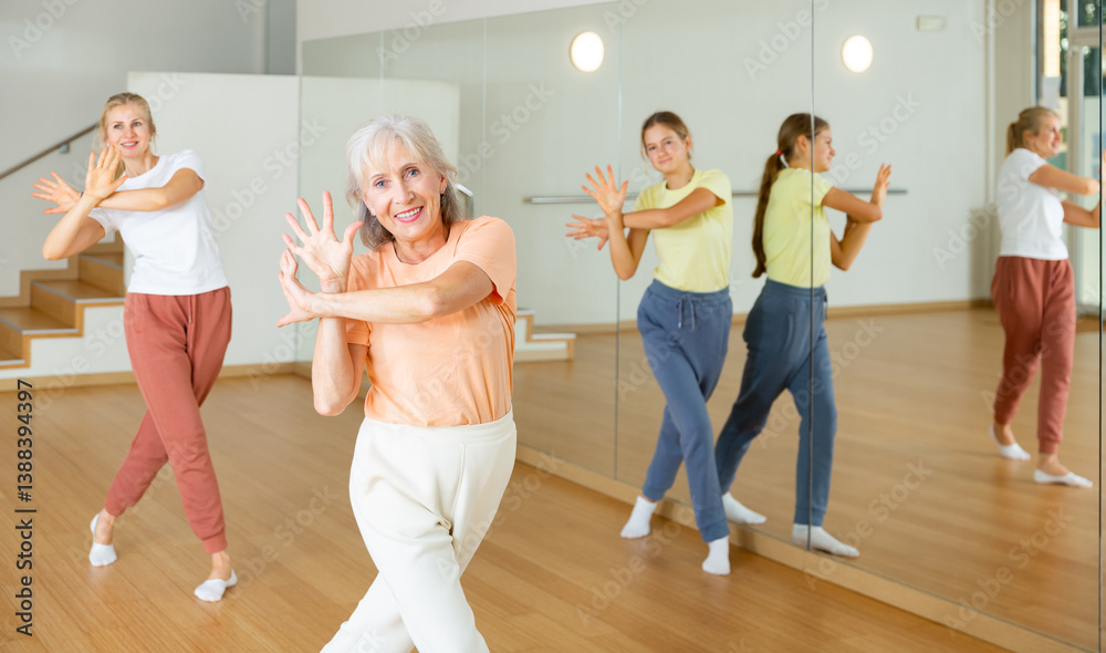 Fototapeta premium Ordinary active females exercising dance moves in dance center