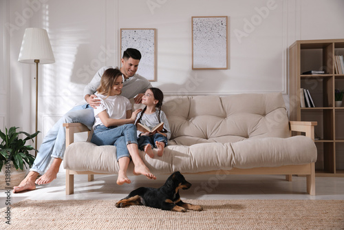 Happy family on sofa and puppy in living room