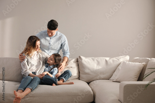 Family with little daughter resting on sofa in living room