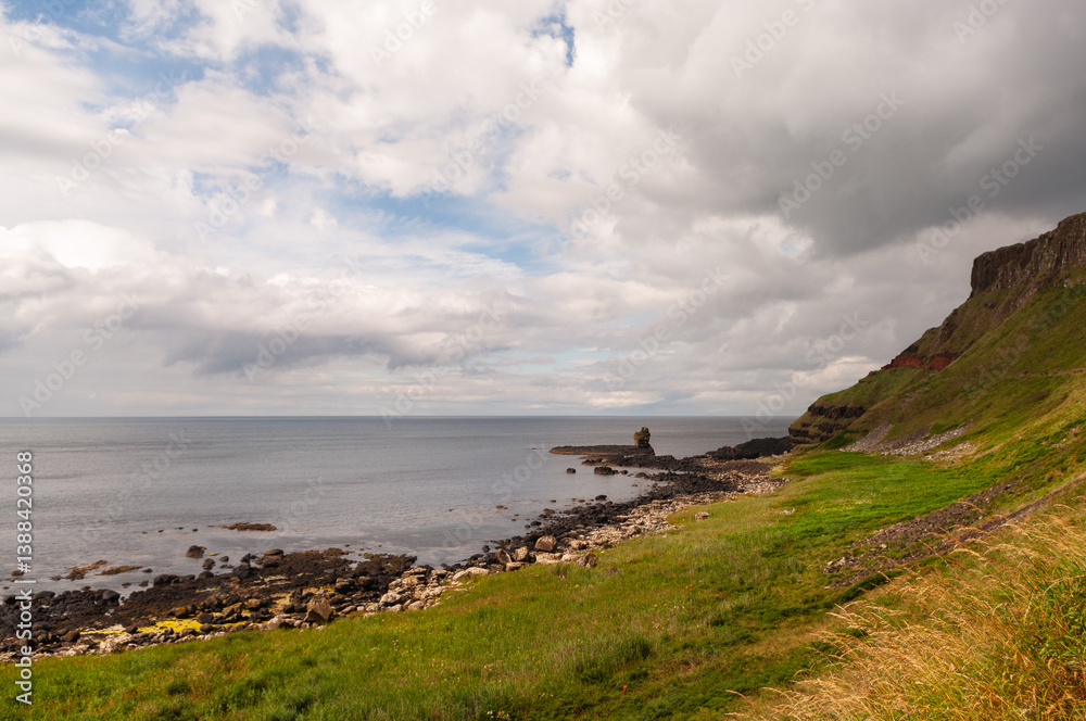 Fototapeta premium A rocky shoreline with a cloudy sky in the background