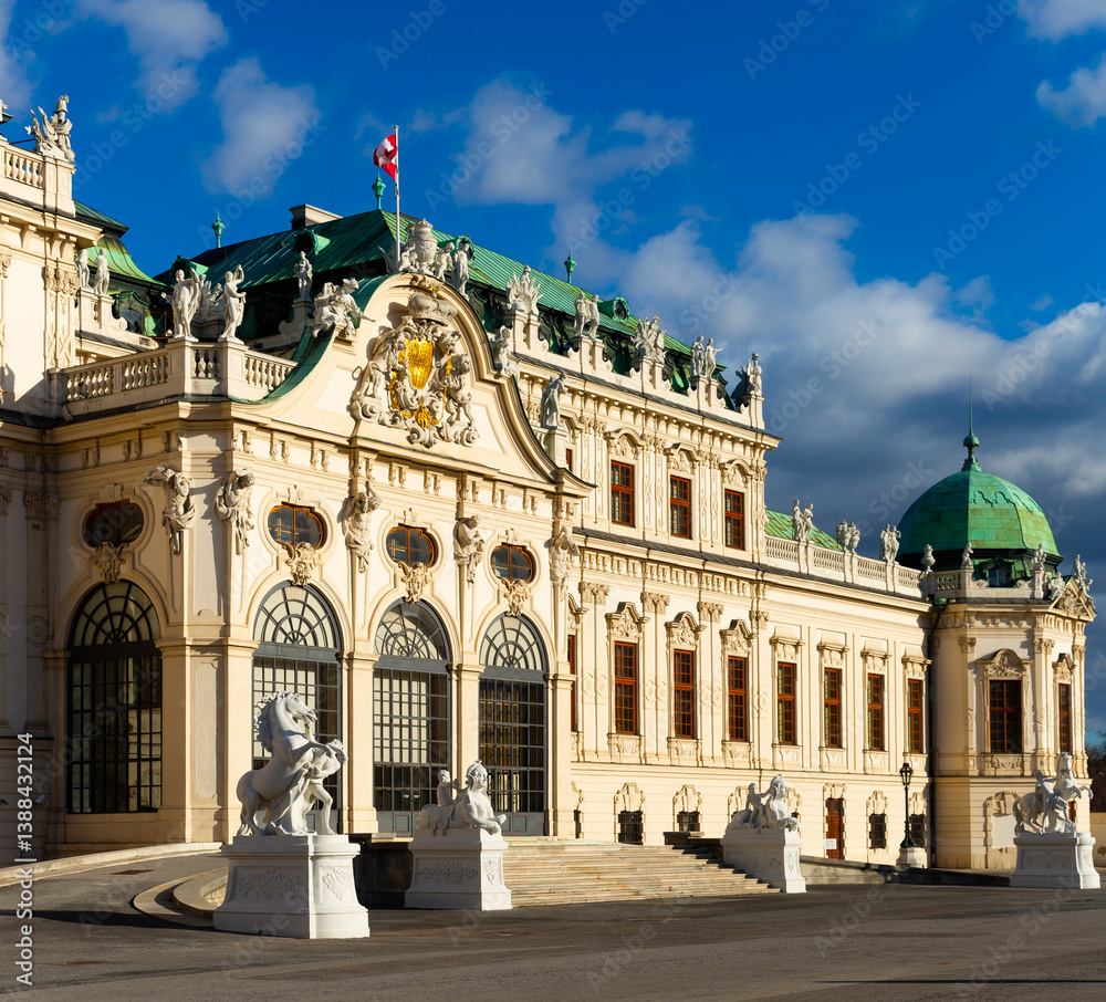 Obraz premium Scenic view of main facade and entrance of baroque building of upper Belvedere palace with large staircase and various sculptures on sunny day, Vienna, Austria