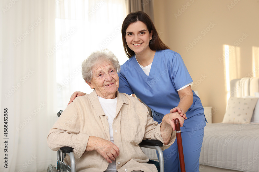 Healthcare worker with elderly woman in wheelchair indoors