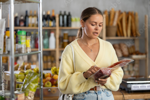 Quadro em tela Customer in store is thinking about buying, considering packaging of meat delicacies, and is interested in shelf life of bacon