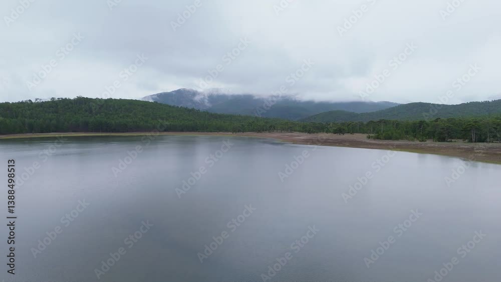 The lake in the forest and the cloudy sky, mountains and hills are a suitable place for camping and vacation.