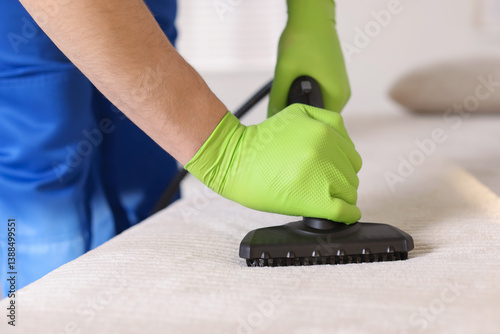 Obraz na płótnie Professional janitor cleaning sofa with vapor steam system at home, closeup w salonie