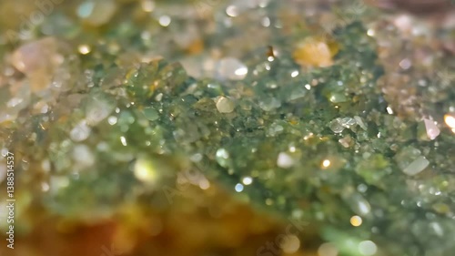 Close-up of sparkling green and yellow Unakite crystals with a blurred background. Mineral pattern texture macro.